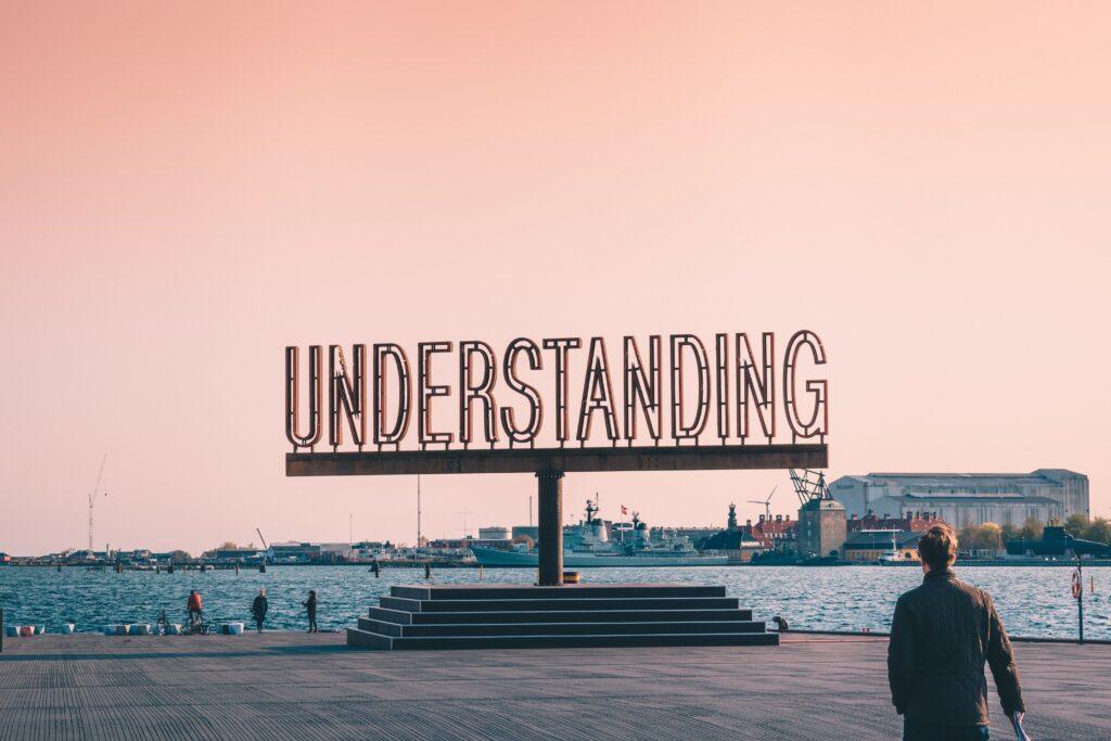 A sign that says "Understanding" on a beach